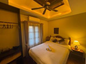 a bedroom with a bed with two stuffed animals on it at Mali House in Luang Prabang