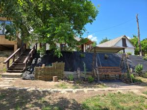 a yard with a bench and a house at Садиба У баби Христі in Shupiki