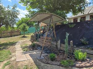 a garden with a bench and an umbrella at Садиба У баби Христі in Shupiki