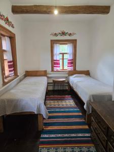two beds in a room with a rug at Садиба У баби Христі in Shupiki