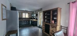 a kitchen with black cabinets and a refrigerator at La BREZOUNIÉRE 2 in Risoul