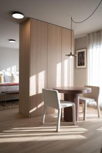 a dining room with a table and chairs and a bed at Stadtloft Suites Cham-Zug in Cham