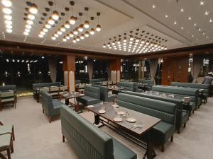 a dining room with tables and chairs and lights at Euphoria The Fine Dine in Surat