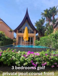 a house with a yellow umbrella and some flowers at vitamin sea villas in Ko Chang