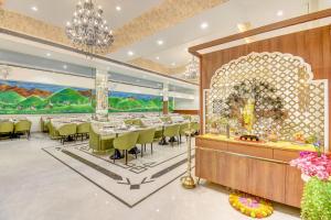 a dining room with tables and chairs and a chandelier at FabHotel Chhappan in Aurangabad