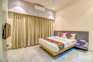 a bedroom with a large bed and a window at FabHotel Chhappan in Aurangabad