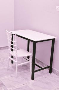 a chair sitting next to a table and a white table and a chair at Kanti Guest House, Arua in Arua