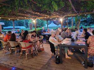 a group of people sitting at tables in a restaurant at Oasis bora bora 4 personnes in Pamiers