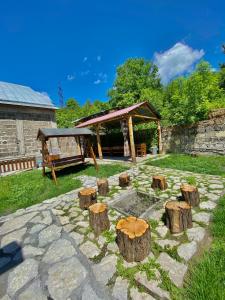a garden with a fire pit and tree stumps at RedRose guest house Dilijan in Dilijan