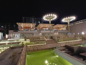 a building with a pool of green water at night at Euphoria The Fine Dine in Surat