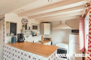 a kitchen with a counter top and a refrigerator at Gîte Sieck Moulin de Kerellec in Plougoulm +16 photos