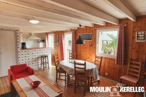 a kitchen and dining room with a table and chairs at Gîte Sieck Moulin de Kerellec in Plougoulm
