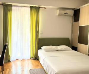 a bedroom with two beds and a window at Cozy City Studio in Podgorica, Blok 9 in Podgorica