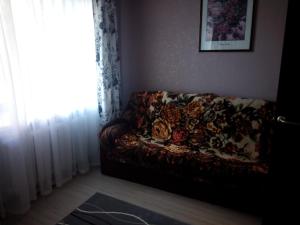 a couch sitting in a living room next to a window at Апартаменты на пр Александра Невского, 43 in Petrozavodsk