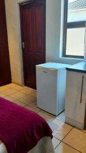 a kitchen with a washer and dryer and a window at Overnight Lodge in Cape Town