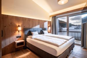 a bedroom with a large bed and a large window at Seefeldstub'n in Kirchberg in Tirol