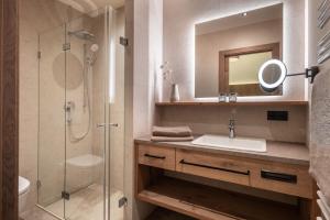 a bathroom with a sink and a shower with a mirror at Seefeldstub'n in Kirchberg in Tirol +28 photos