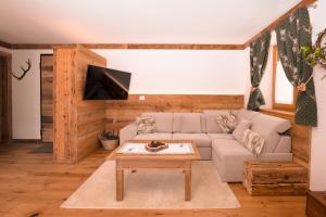 a living room with a couch and a coffee table at Arga' New Alpine Design Apartment Central & Scenic Views in San Vito di Cadore