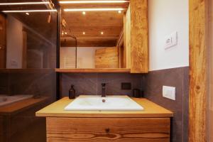 a bathroom with a sink and a mirror at Arga' New Alpine Design Apartment Central & Scenic Views in San Vito di Cadore +12 photos