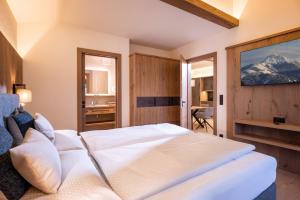 a bedroom with a large white bed in a room at Seefeldstub'n in Kirchberg in Tirol