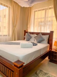 a large bed in a bedroom with a window at Nitro Homes Nyali-Coral Sands in Mombasa +5 photos