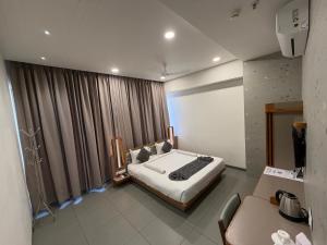 a bedroom with a bed and a large window at Euphoria The Fine Dine in Surat