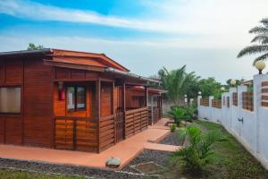 a wooden cabin in a yard next to a fence at EcoResorTamarino in M. Peixe