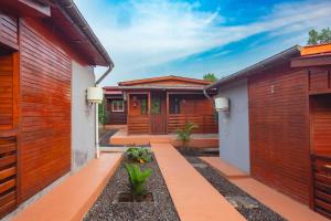 a home with wooden walls and a pathway between two buildings at EcoResorTamarino in M. Peixe +18 photos