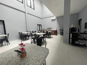 a restaurant with tables and chairs and a table with a flower on it at Agiva Hotel in Kurinci