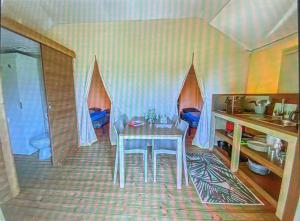 a room with a table and a kitchen with a sink at glamping eco lodges in Moncarapacho