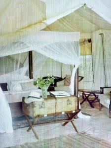 a room with a bed and a table with flowers on it at glamping eco lodges in Moncarapacho