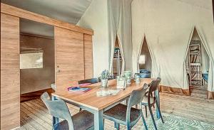a dining room with a wooden table and chairs at glamping eco lodges in Moncarapacho