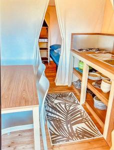 a room with a tent with a table and shelves at glamping eco lodges in Moncarapacho