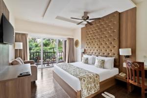 a hotel room with a bed and a balcony at Riva Beach Resort in Mandrem