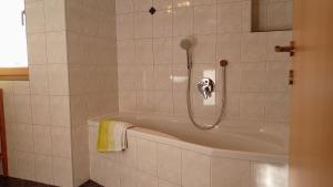 a bathroom with a bath tub with a shower at Agriturismo Ferienhof Gschloier - Adults Only in Laion +43 photos