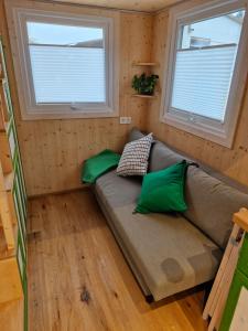 a couch in a tiny house with two windows at Tiny House Reichle in Boms +10 photos