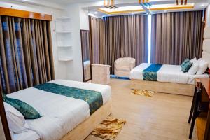 a hotel room with two beds and a desk and a bedroom at The Elegance Hotel & Suites in Chittagong +29 photos