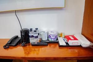 a wooden table with a coffee maker and remote controls at The Elegance Hotel & Suites in Chittagong