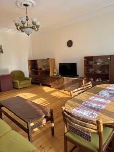 a living room with a table and a television at RedRose guest house Dilijan in Dilijan