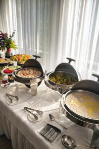 a buffet line with bowls of food on a table at Hotel Expo in Yunusobod