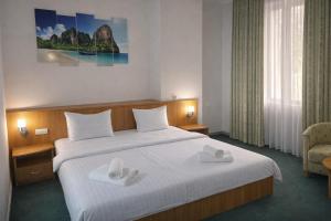 a hotel room with a large bed with towels on it at Hotel Expo in Yunusobod +36 photos