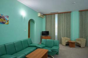 a living room with a couch and a tv at Hotel Expo in Yunusobod