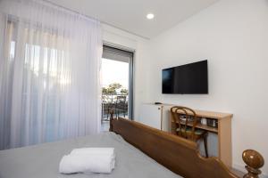 a bedroom with a bed and a tv and a window at Apartments Klaricic in Živogošće