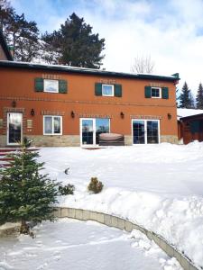an orange house with snow in front of it at Apartmán pri vinotéke in Kežmarok