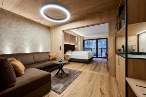 a living room with a couch and a bed at VALARA Alpine Art Hotel in Tux