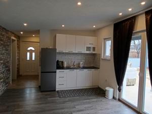 a kitchen with white cabinets and a refrigerator at Apartment Lane in Bihać