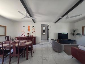 a living room with a dining room table and a couch at La Petite Case Tomi in Saint-Louis