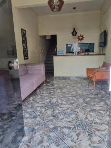 a living room with a pink couch and a staircase at Hostal B&C in Angra dos Reis