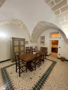 a dining room with a wooden table and chairs at Villa Del Prete in Nardò