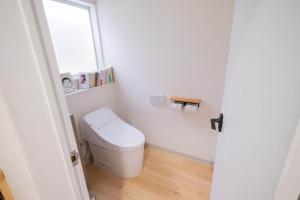a white bathroom with a toilet and a window at 里山ハウス in Kamogawa +15 photos